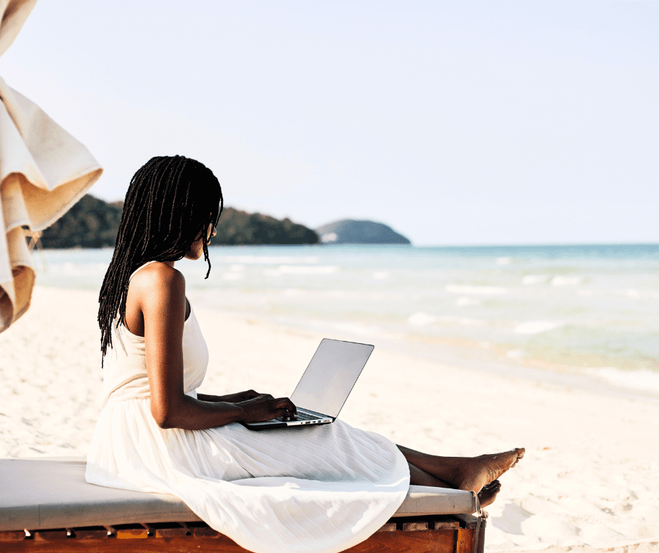 Lady sitting in a chair on the beach with her laptop